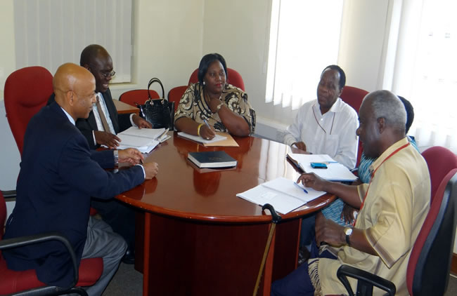 dr alemu in blue jacket in discussion with dr mbidde attended by who and uvri staff.