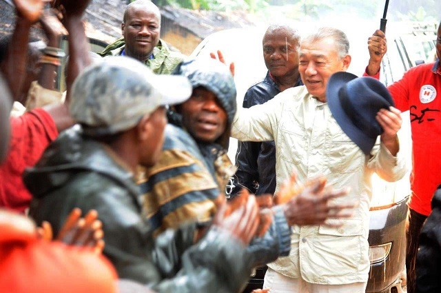 M. Yohei SASAKAWA esquissant quelques pas de danse avec les autochtones de Bokatola, sous la pluie, lors de la visite de la délégation conjointe Nippon Foundation-MSP-OMS