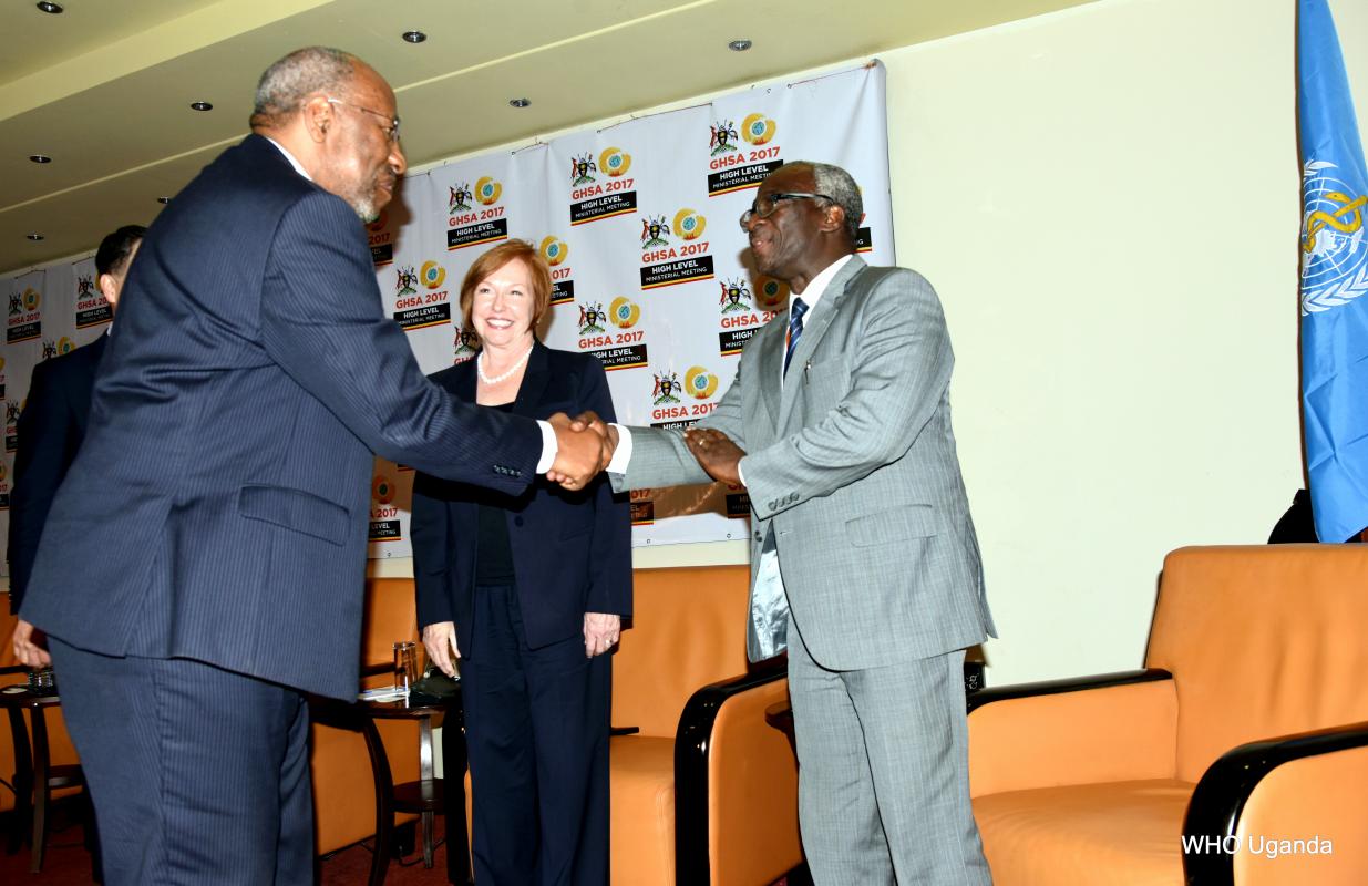 Prime Minister of Uganda Dr. Ruhakana Ruganda (left) greets WHO’s Director of Program Management- Dr. Joseph Kabore (left) as Director of the U.S. Centers for Disease Control and Prevention, Dr. Brenda Fitzgerald (inset) looks on