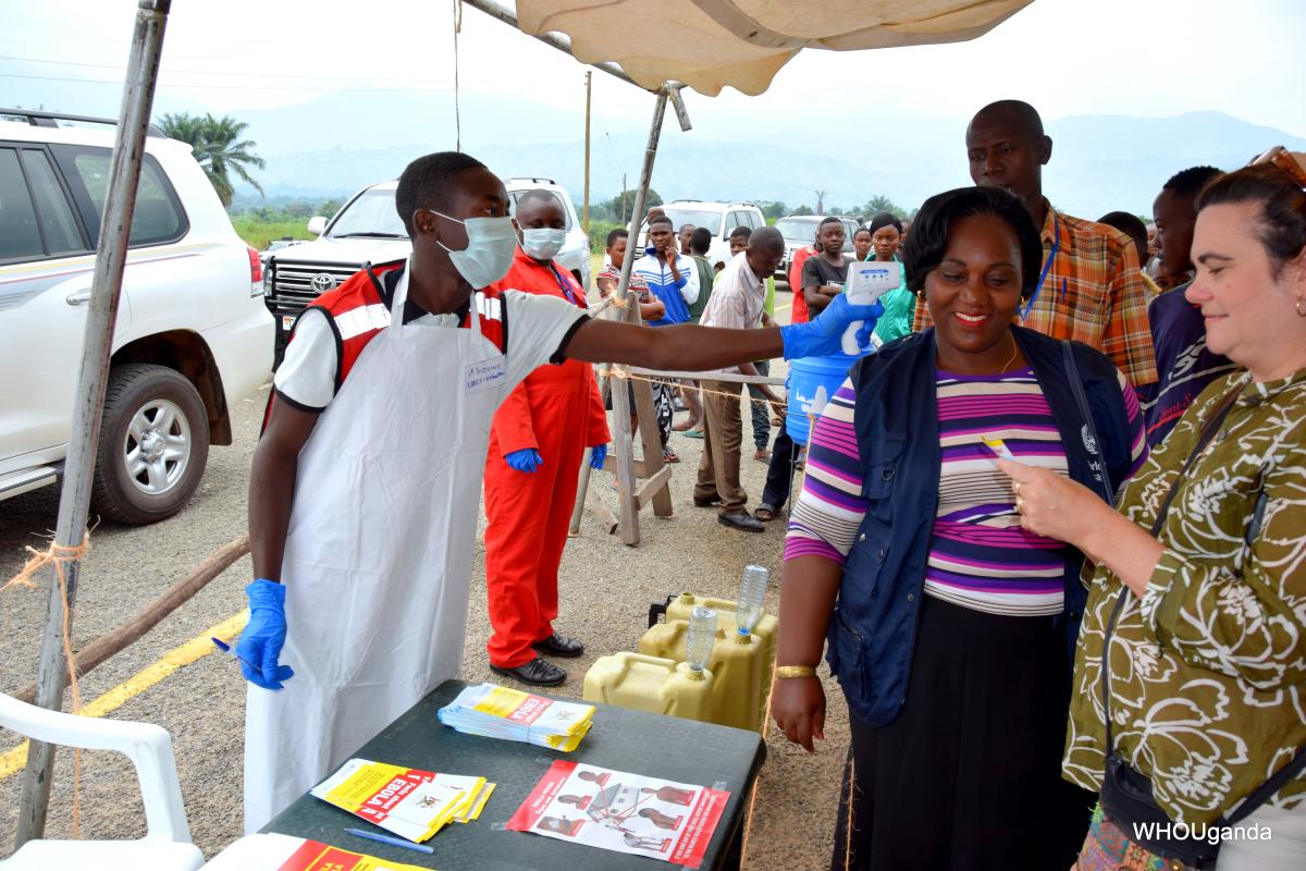 A Red Cross Volunteer demonstrates to WHO officials and other partners, how screening is done at the points of entry