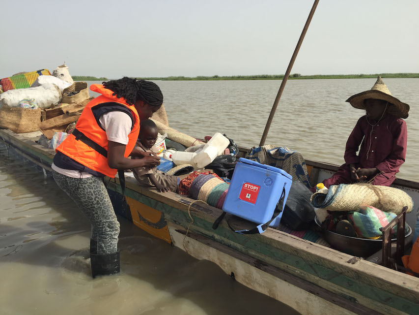 A WHO doctor vaccinates a child who is travelling between the islands of Lake Chad, while also conducting measles surveillance.  ©WHO