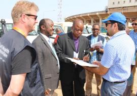 The Deputy Minister of Health (Administration), Hon. Mathew T.K. Flomo ( 2nd from right) signing the certificate of transfer of vehicles in the presence of the WHO Representative, Dr. Alex Gasasira (second from left)