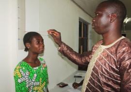 A young girl assisted in measuring her BMI