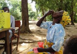 A woman taking a swig of the Oral Cholera Vaccine in Nsanje