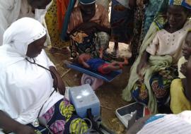 18-day old baby weighed before receiving vaccines