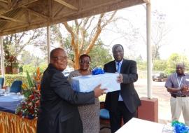 Dr Okello presenting farewell gift to Dr and Mrs Charimari