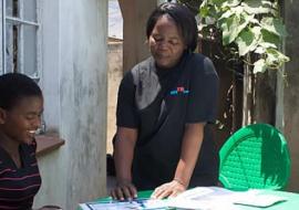 A health worker explains the process of HIV self-testing to a young woman.