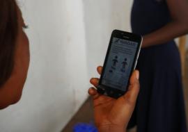 A community member putting the new technology into use to report suspected AFP cases in her locality