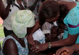 Minister of Health and Sanitation Madam Miata Kargbo officially giving the first Vitamin A capsule at the launc