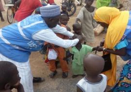 WHO personnel vaccinating a child in Gwoza