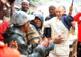 M. Yohei SASAKAWA esquissant quelques pas de danse avec les autochtones de Bokatola, sous la pluie, lors de la visite de la délégation conjointe Nippon Foundation-MSP-OMS