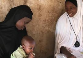 A community oriented resource person in Niger State examines a young child for pneumonia