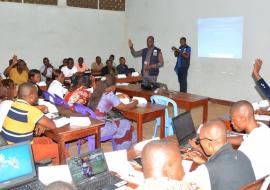 Le Dr Jean-Paul Ngandu, consultant de l'OMS spécialiste en prévention et contrôle de l'infection en pleine discussion avec les prestataires de la zone de santé de Bolenge dans une des salles du Centre de formation des cadres de l'EPSP Mbandaka . OMS/Eugene Kabambi