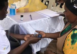 Health worker tests a community member for blood pressure during the commemoration