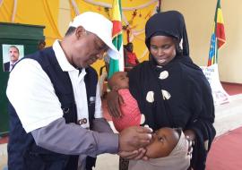 WHO Colleague vaccinating a child during the launching of mOPV2 vaccination