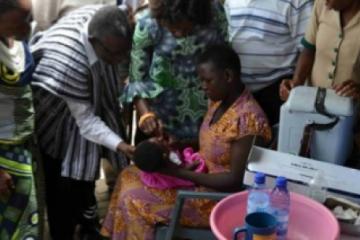 Baby Ernestina receiving Oral Polio Vaccine from the Minister of health