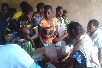 WHO Emergency Response Team member dispensing drugs at a mobile clinic WHO/H. Kubwalo