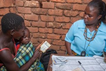 A community health worker, Frida Kabwango, diagnoses and treats 3 year old James Mabvuto for malaria at Matapila Village Clinic in Ntcheu District, Malawi. WHO / A. Gumulira