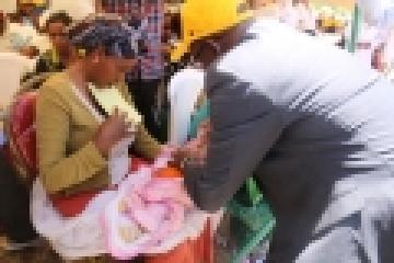 Representative of WHO Dr Thomas  Karengera vaccinating a child