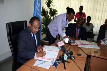 The WHO Representative, Dr. Rufaro Chatora and the Minister for Health and Social Welfare, Hon.Dr Hussein Ali Mwinyi signing certificates of transfer