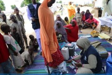 WHO supported Hard to Reach team staff weighs a pregnant woman during one of the outreach in Muna garage IDP camp in Maiduguri, Borno State