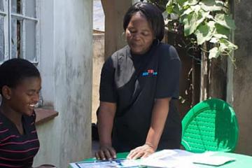 A health worker explains the process of HIV self-testing to a young woman.