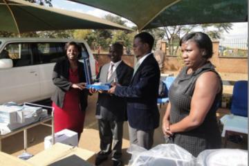 Dr Beatrice Mwagomba handingover a blood pressure machine to the Dr Nkambule, DHO Kasungu standing second left