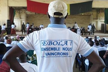 Man wearing tshirt with text "together we shall overcome Ebola" at a social mobilization event in Guinea WHO /Cristiana Salvi