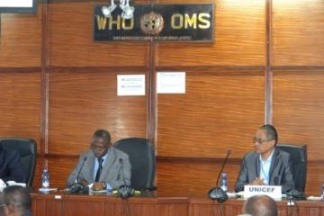 Dr Deo Nshimirimana, Représentant de l’OMS ad intérim _à gauche_ prononçant son allocution en présence de Baitsura Musowa, Directeur de Cabinet du Ministre de la Santé Publique _au centre_