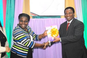 WHO Officer, Dr Joyce Nato receives the launched strategy document from DMS Dr Jackson Kioko