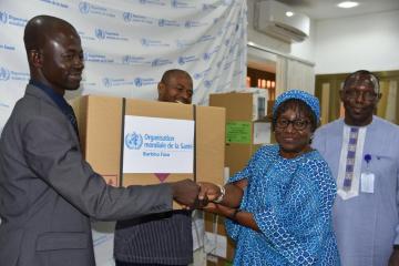 Directeur de Cabinet du Ministère de Santé, Monsieur Emmanuel Sorgho, is receiving a kit from the Burkina Faso WR Dr. Alimata J. Diarra-Nama.