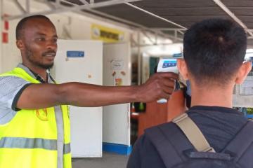 Primary screening includes temperature measurement and visual observation of travelers to look for signs of illness. © WHO/Tania Seburyamo  