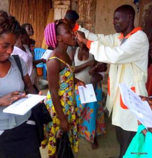 A health worker administers the Cholera vaccine to a mother in Hoima District 