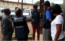 WHO staff demonstrating infrared thermometer on the Minister. The thermometer will be distributed to Ebola contact tracers to prevent direct contact with probable cases