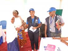 WHO Staff handing over vaccination card to the vaccinated girl