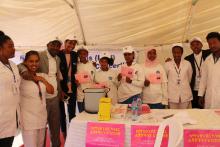 Girls from Tesfa Kokeb Primary School that received the HPV vaccine  displaying the vaccination cards they received with WHO and MOH staff. 