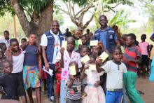 Vaccinated children proudly show off their new vaccination card after receiving the YF vaccination in Sakure Payan