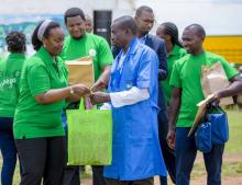 Minister of Health, Dr Diane Gashumba offering materials to CHW in Nyagatare District