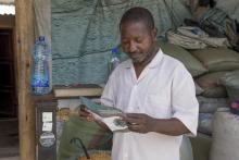 A business man at the market reading the COVID-19 brochure